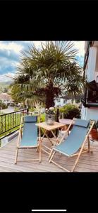 2 sillas y una mesa en una terraza con una palmera en La Suite, en Baden-Baden