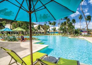 uma piscina num resort com cadeiras e um guarda-sol em Margaritaville Vacation Club by Wyndham - St Thomas em Frydendal