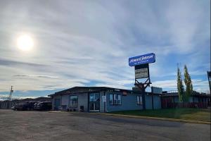 ein blaues Gebäude mit einem Schild darüber in der Unterkunft Howard Johnson by Wyndham Grande Prairie in Grande Prairie