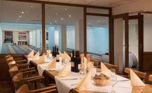 uma fila de mesas num restaurante com garrafas de vinho em Best Western Hotel Braunschweig Seminarius em Braunschweig