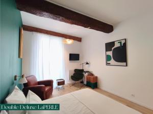 a bedroom with a bed and a couch and a chair at Le Prince in Marseillan
