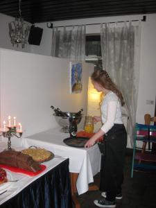 una mujer parada frente a una mesa preparando comida en Leuchtners an der Rennbahn, en Iffezheim