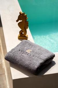 a towel sitting on a table next to a pool at Kasteli Suites in Perivolos