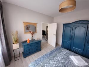 1 dormitorio con 1 cama azul y vestidor azul en Lovely Apartment Near City Center (w/ Parking) en Cluj-Napoca