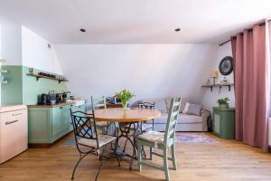 a kitchen and dining room with a table and chairs at Kamienica Stare Miasto- Św . Ducha. in Elblag