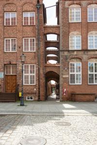 un edificio de ladrillo con un arco delante de él en Kamienica Stare Miasto- Św . Ducha. en Elblag