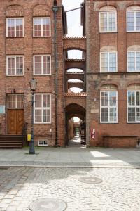 a brick building with an archway in front of it at Kamienica Stare Miasto- Św . Ducha. in Elblag