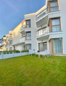 ein Apartmenthaus mit einer Liegewiese davor in der Unterkunft Apartament MORZA SZUM Gąski in Gąski