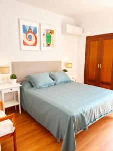 ein Schlafzimmer mit einem großen Bett mit blauen Kissen in der Unterkunft Apartamento Medina in Fuengirola