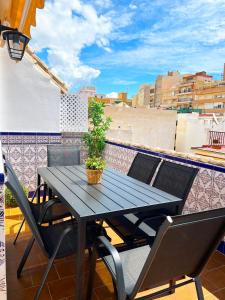 un tavolo nero con sedie e una pianta in vaso sul balcone di Apartamento Medina a Fuengirola
