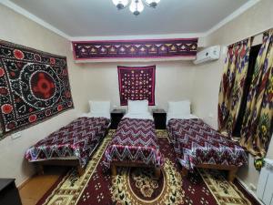 a room with two beds and a rug at Hotel Registon Zargaron in Samarkand
