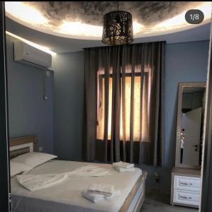 1 dormitorio con cama con espejo y ventana en Hotel Universi, en Kolgecaj