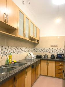 a kitchen with wooden cabinets and a counter top at Queen Room Semi Attached Bathroom Bukit Mertajam Alma Impian in Bukit Mertajam