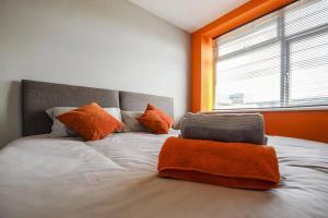 a bedroom with a bed with orange walls and a window at PRIMEEE LOCATION - Modern Central Apartment in Bristol