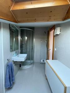 a bathroom with a glass shower and a sink at Ático en Cambados in Cambados
