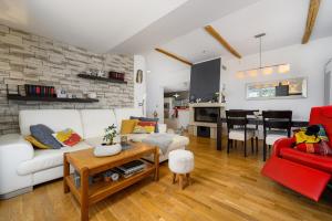 ein Wohnzimmer mit einem weißen Sofa und einem roten Sessel in der Unterkunft Apartment David in Dračevac