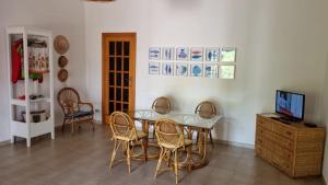 a dining room with a table and chairs and a television at La Villetta al Mare in Porto Cesareo