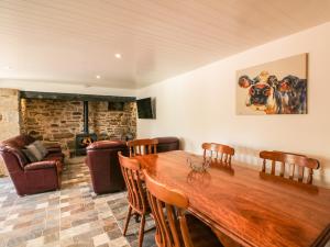 a dining room with a wooden table and a fireplace at Yew Tree House in Marley Bridge