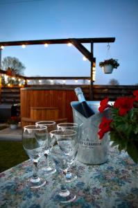 three wine glasses on a table with a vase of flowers at Kõrtsitoa Puhkemaja in Unukse