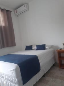 1 dormitorio con 1 cama grande con sábanas azules y blancas en Pousada Central-Ubajara Capital do Turismo, en Ubajara
