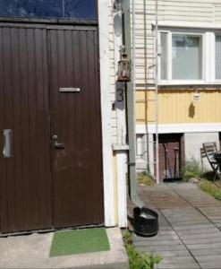 a brown door of a house next to a building at Sadan vuoden talo in Pori