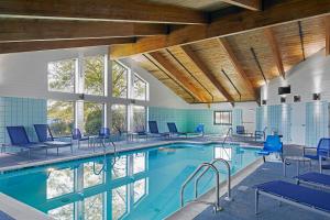 a swimming pool with blue chairs in a building at Hotel Wave at Rehoboth Beach in Rehoboth Beach