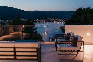 a balcony with chairs and a view of the water at High View House in Okrug Donji