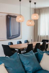 a dining room with a table and chairs and pendant lights at High View House in Okrug Donji
