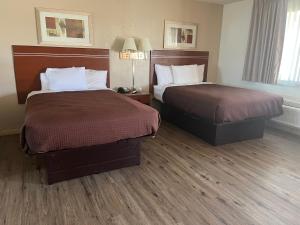a hotel room with two beds and two lamps at Valley Motel in Alamosa