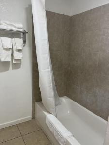 W łazience znajduje się biała wanna i ręczniki. w obiekcie Valley Motel w mieście Alamosa