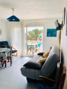 - un salon avec un canapé et une table dans l'établissement Carnac plage T2 avec terrasse Pour 4 personnes, à Carnac