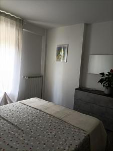 ein Schlafzimmer mit einem Bett und ein Fenster mit einer Pflanze in der Unterkunft apartment GiòHome in Grado