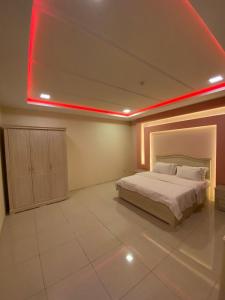 Schlafzimmer mit einem Bett mit roter Decke in der Unterkunft شقق ليالي الشرق للوحدات 3 in Al-Hasa