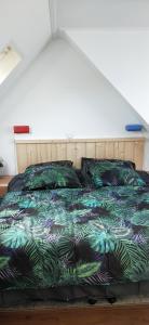 - une chambre avec un lit doté d'une couette et d'oreillers verts dans l'établissement De Berin, à Westhoek