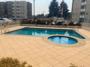 a swimming pool in the middle of a parking lot at Depto full equipado con estacionamiento y piscina in Temuco