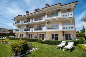 an apartment building with chairs in the yard at Lagaria Apartments in Afitos