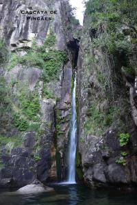 una cascada en el lado de una montaña en el agua en Casinha Estrela da Encosta - Gerês en Vieira do Minho