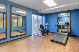 un gimnasio con paredes azules, cinta de correr y espejo en Comfort Inn & Suites SW Houston Sugarland en Houston
