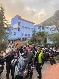 Eine Gruppe von Menschen, die sich für ein Bild mit Motorrädern posieren in der Unterkunft Hotel Alkhalifa in Chefchaouen