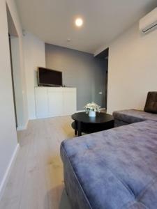um quarto com um sofá, uma mesa e uma televisão em Molino Apartamentai em Palanga