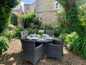 a table and chairs in a garden with a table and chairs at Quintessential Cottage near Bath, Grade 2 Listed. in Paulton