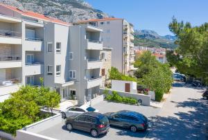 a parking lot in front of a building with cars parked at Apartments M&A in Makarska
