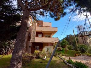 a house with a tree in front of it at Arena de Mar depto A in Mar de las Pampas