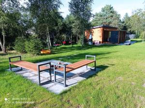een houten bank en een tafel in een veld bij ApartDomek CICHE in Zbiczno