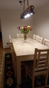 a dining room table with a vase of flowers on it at Bienvenidos a Valdivia in Valdivia +10 photos