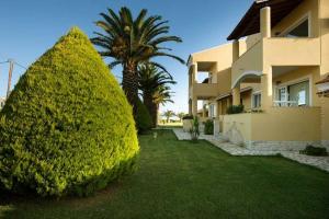 a large green bush next to a house at Residence Vista Del Mare in Acharavi