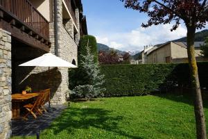 patio ze stołem i parasolem na dziedzińcu w obiekcie Apartamento con jardín en la Cerdanya w mieście Err