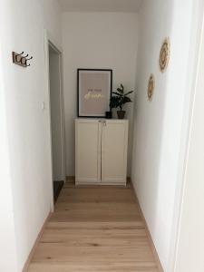 Apartment in Gmunden في غموندين: مدخل بجدران بيضاء وصورة على الحائط