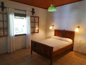 um quarto com uma cama e uma janela num quarto em Villa Lena Entire cottage em Kalamákion