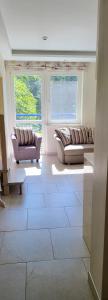 a living room with two couches and two windows at Pergolt Apartment in Pervalka +1 photo